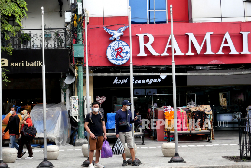 Wisatawan bermasker menunggu jemputan di Malioboro, Yogyakarta, Senin (21/6). 