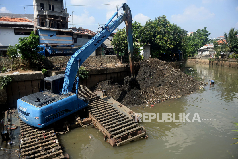 Petugas mengoperasikan ekskavator untuk mengeruk lumpur anak kali Ciliwung di Kenari, Jakarta.