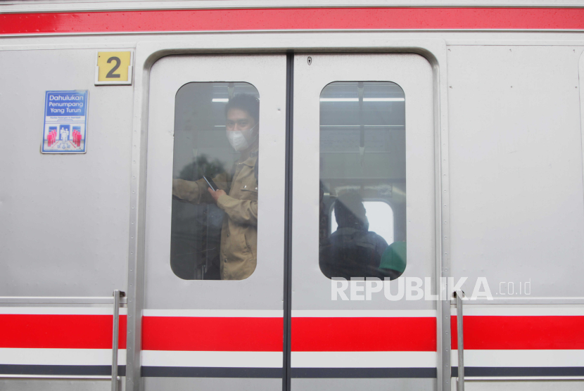Warga menaiki KRL Commuter Line di perlintasan Pondok Ranji-Kebayoran, Bintaro, Jakarta Selatan, Selasa (25/7/2023).
