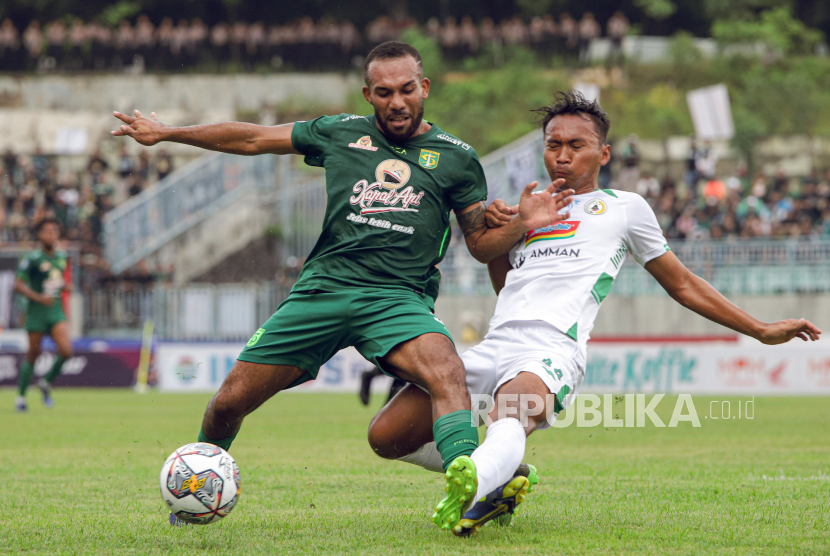 Pesepak bola Persebaya Surabaya Michael Bonjozi Rumere (kiri) berebut bola dengan pesepak bola PSS Sleman Nur Diansyah (kanan) dalam lanjutan BRI Liga 1 di Stadion Gelora Joko Samudro, Gresik, Jawa Timur, Senin (13/2/2023). Persebaya Surabaya mengalahkan PSS Sleman dengan skor 4-2. ANTARA FOTO/Rizal Hanafi/Zk/rwa.