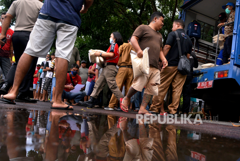 Ratusan supir angkot yang penghasilnnya menurun akibat dampak Covid-19 mengantre paket bantuan di Manado, Sulawesi Utara, Selasa (31/3/2020). Pemerintah pusat telah menyiapkan sejumlah program jaring pengaman sosial bagi masyarakat di lapis ekonomi paling bawah.
