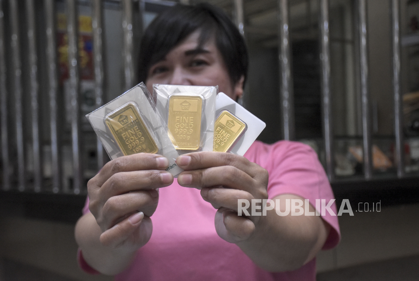 Karyawan menunjukkan emas batangan di salah satu toko emas dan perhiasan di Kota Bandung, Jawa Barat, Senin (16/10/2023). Harga emas batangan PT Aneka Tambang Tbk (Antam) tetap tinggi meski mengalami penurunan pada hari ini, Senin (16/10/2023). Untuk pecahan satu gram, emas batangan Antam dihargai Rp1.087.000 dari sebelumnya Rp1.088.000 per gram. Sementara harga pembelian kembali (buyback) tidak bergerak dan bertahan di level Rp969.000.