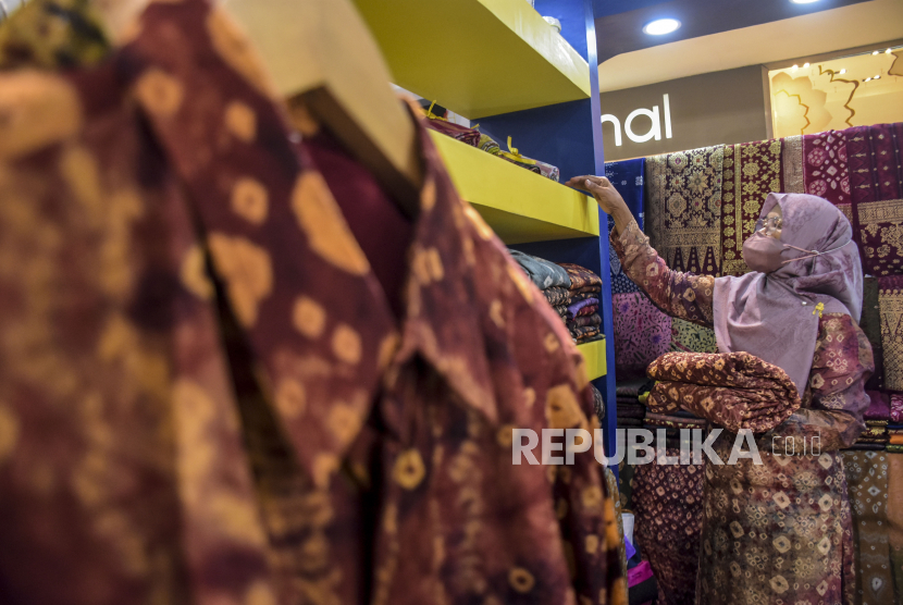 Pelaku UMKM menata produk fesyen di salah satu stan pada Hari Nasional (Harnas) UMKM Bandung 2022 di Cihampelas Walk, Jalan Cihampelas, Kota Bandung, Jumat (12/8/2022). PT Bank Rakyat Indonesia Tbk (BRI) turut menyalurkan bantuan program Pemulihan Ekonomi Nasional (PEN).