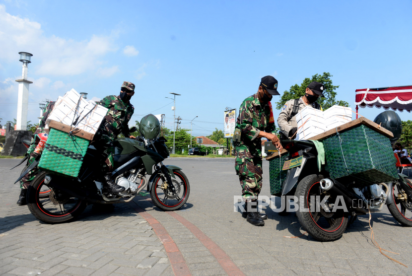 Aparat TNI dan Polisi bersiap mendistribusikan makanan untuk warga kurang mampu di Posko Sinergitas Dapur Umum Peduli Covid 19 di Pasar Seni Gabusan, Bantul, Yogyakarta, Jumat (8/5). (ilustrasi)