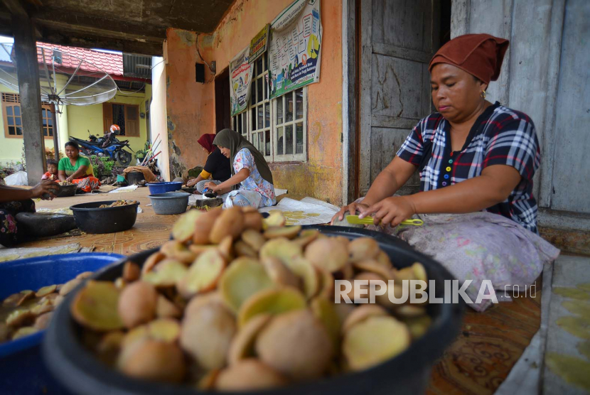 Warga menumbuk buah jengkol agar menjadi kerupuk, di Korong Jambak, Nagari Kasang, Kabupaten Padangpariaman, Sumatera Barat, Jumat (21/10/2022). Kerupuk jengkol yang diproduksi oleh warga dalam skala industri rumahan tersebut dijual Rp100 ribu per kilogram untuk kualitas terbaik.  