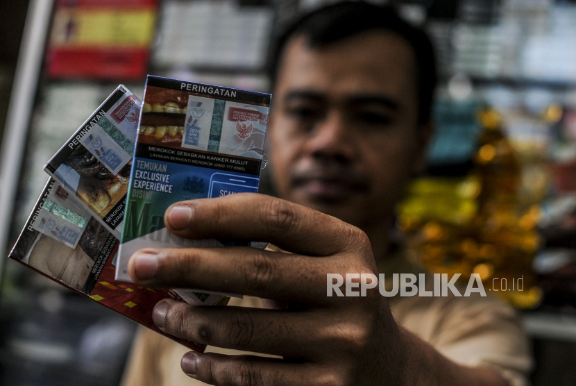Pedagang menunjukkan bungkus rokok bercukai di Jakarta, Kamis (10/12). Pemerintah resmi menetapkan rata-rata kenaikan tarif cukai rokok sebesar 12 persen pada tahun depan. 