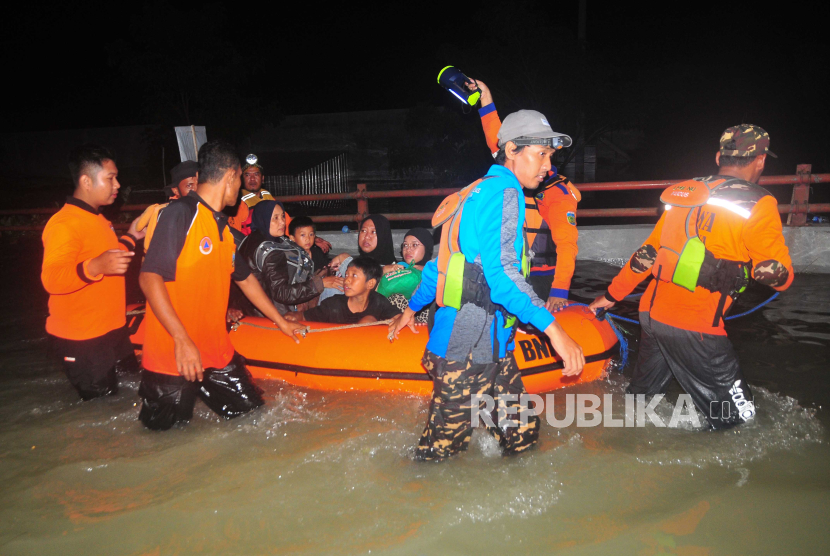 Relawan gabungan mengevakuasi warga yang terjebak banjir di Karanganyar, Kabupaten Demak, Jawa Tengah, Jumat (9/2/2024). 