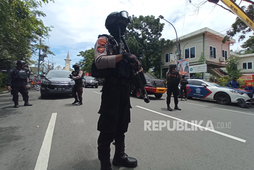 Petugas kepolisian berjaga di lokasi dugaan bom bunuh diri di depan Gereja Katedral Makassar, Sulawesi Selatan, Ahad (28/3/2021).