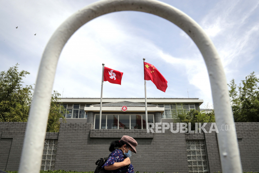Seorang wanita yang mengenakan masker wajah berjalan oleh gedung kantor Daerah Administratif Khusus Hong Kong di Beijing, Selasa, 30 Juni 2020. Indonesia masih tetap menghormati prinsip China kepada wilayah semi otonom Hong Kong. Ilustrasi.