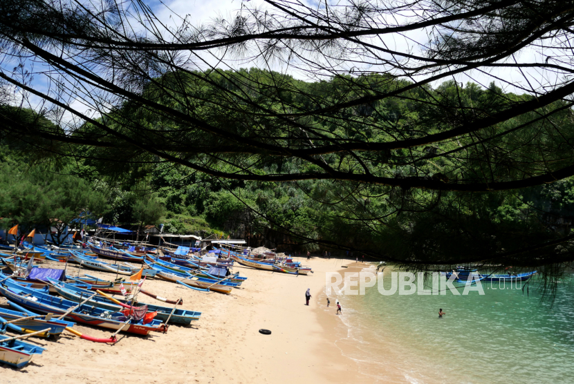 Wisatawan menikmati pasir putih di Pantai Gesing, Panggang, Gunungkidul, Yogyakarta.