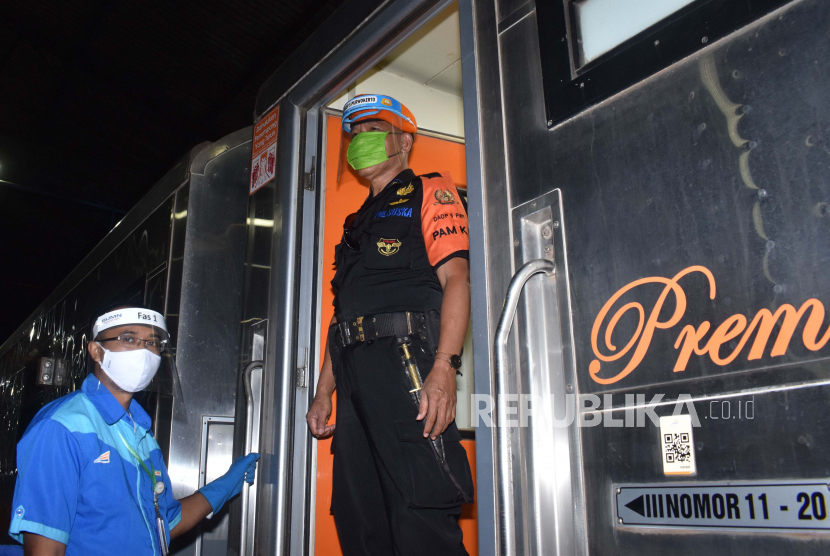 Petugas menggunakan masker dan pelindung wajah guna mencegah penularan COVID-19 di Kereta Api Luar Biasa (KLB) relasi Gambir – Surabaya Pasarturi saat tansit di Stasiun Kereta Api Madiun, Jawa Timur, Senin (8/6/2020). PT KAI memperpanjang masa pengoperasian KLB hingga 11 Juni, dan kereta yang sebelumnya hanya mengangkut penumpang khusus masyarakat yang dikecualikan tersebut mulai Senin (8/6) juga diperuntukkan bagi masyarakat umum dengan syarat menunjukkan bukti bebas COVID-19