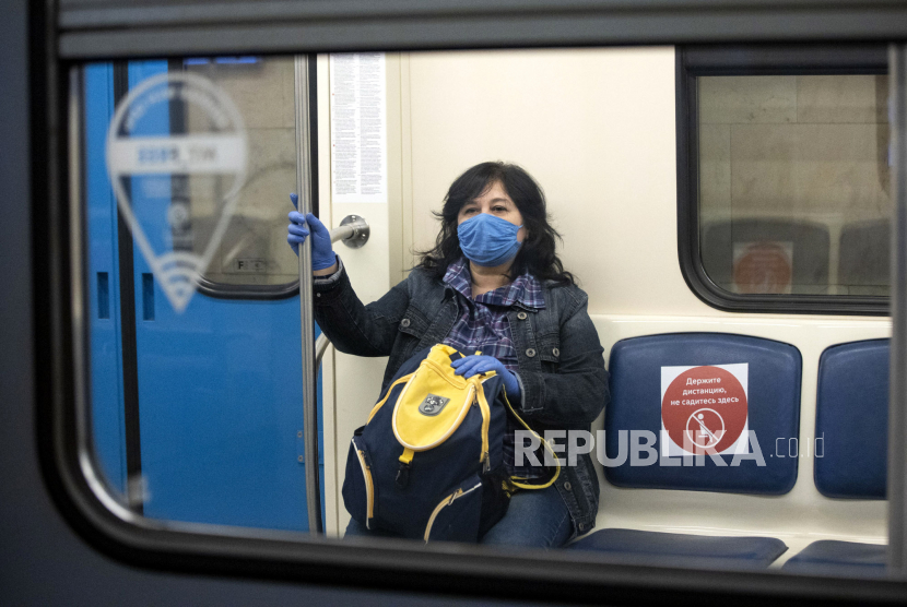 Seorang wanita mengenakan masker dan sarung tangan di dalam kereta bawah tanah di Moskow, Rusia, Selasa (12/5). Lebih dari 300 ribu orang meninggal akibat virus corona di seluruh dunia. Ilustrasi.