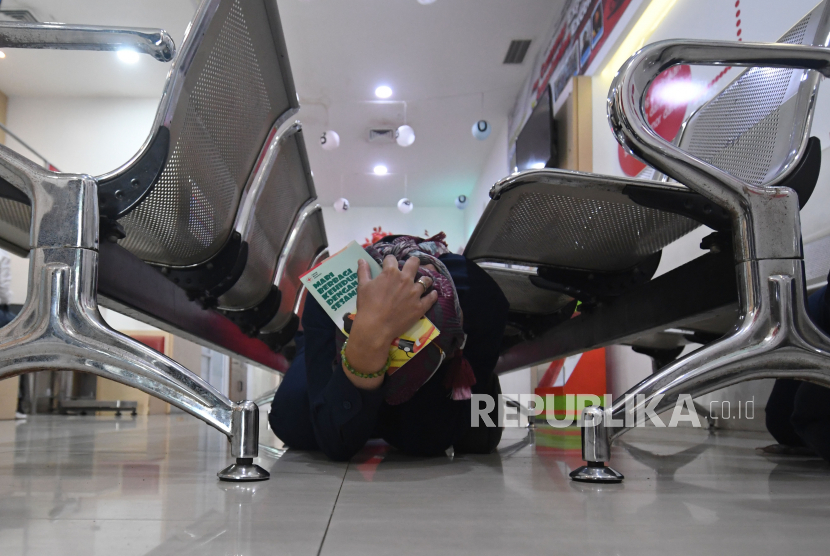 Karyawan berlindung di bawah kursi besi dalam simulasi kesiapsiagaan bencana gempa bumi di Gedung Palang Merah Indonesia (PMI) DKI Jakarta, Jakarta, Selasa (26/4/2022). Indonesia memiliki banyak kearifan lokal terkait penanganan bencana. Ilustrasi.