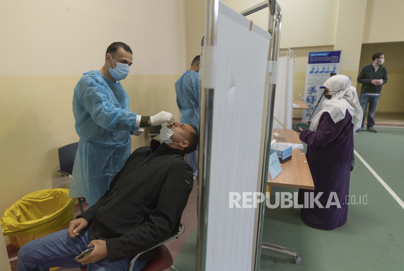  Seorang petugas kesehatan mengambil sampel usap hidung di pusat pengujian COVID-19, di Kompleks Medis Palestina, di kota Ramallah, Tepi Barat, Selasa, 2 Maret 2021.