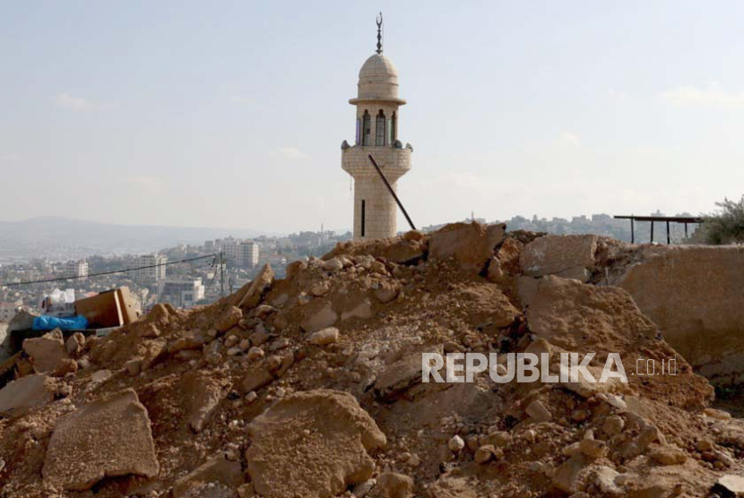 Sebuah menara masjid terlihat di belakang bangunan yang rusak menyusul penggerebekan Israel di kamp pengungsi Jenin, di kota Jenin, Tepi Barat, 3 November 2023.