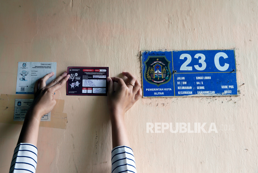 Petugas Pemutakhiran Data Pemilih (PANTARLIH) KPU Kota Bitar menempelkan stiker di rumah warga sebagai tanda sudah terdata saat melakukan pencocokan dan penelitian (COKLIT) data pemilih untuk Pemilu 2024 di Kota Blitar, Jawa Timur.