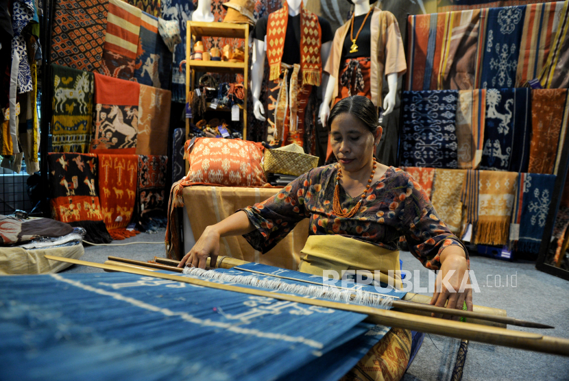 Pengrajin menyelesaikan pembuatan kain tenun pada gelaran International Handicraft Trade Fair (Inacraft) on October 2023 di Jakarta Convention Center, Jakarta, Sabtu (7/10/2023). 