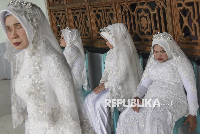 Sejumlah pengantin tuna netra menunggu pasangannya saat berlangsungnya nikah massal tuna netra se-Priangan Timur di Gedung Aisyah, Kota Tasikmalaya, Jawa Barat, Selasa (31/12/2024). Pernikahan massal gratis yang diikuti lima pasangan pengantin tuna netra itu untuk membantu para penyandang disabilitas yang tidak mampu secara ekonomi dalam mendapatkan legalitas secara hukum negara. 