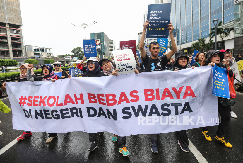 Sejumlah aktivis dari Jaringan Pemantau Pendidikan Indonesia berjalan sambil membentangkan spanduk dan poster saat aksi pada Hari Bebas Kendaraan Bermotor (HBKB), di kawasan Bundaran HI, Jakarta, Ahad (7/7/2024). Mereka menyerukan agar sekolah negeri dan swasta bebas biaya, tidak ada jual beli bangku sekolah, dan mendesak perubahan sistem dalam Penerimaan Peserta Didik Baru (PPDB). 