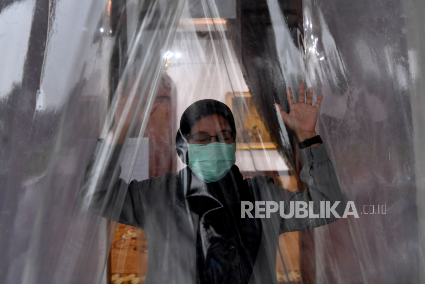 Pengunjung memasuki bilik disinfektan atau bilik sikat Corona (Sico) ketika keluar dari Gedung Negara Grahadi di Surabaya, Jawa Timur, Senin (23/3/2020). 