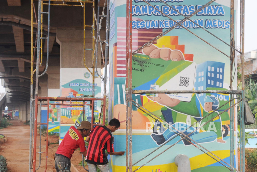 Pekerja sedang menyelesaikan pembuatan mural di kolong jalan layang Tol Becakayu, Jakarta, Rabu (25/10/2023). Pekerja informal yang seringkali bekerja di lingkungan tidak aman, berisiko tinggi, berpenghasilan rendah. Sehingga tidak mampu membayar iuran jaminan sosial Ketenagakerjaan secara mandiri dan berkelanjutan.BPJS Ketenagakerjaan/ BP Jamsostek mengakomodasi pemberian perlindungan jaminan sosial ketenagakerjaan kepada pekerja rentan dalam program, Jaminan Kecelakaan Kerja (JKK), Jaminan Kematian (JKM). 