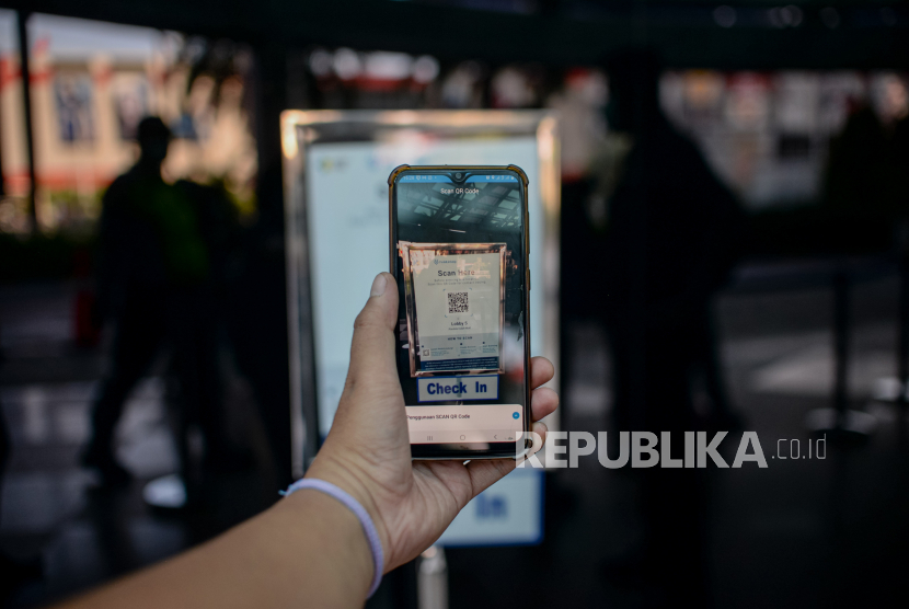 Pengunjung memindai QR code aplikasi pedulilindungi untuk pendaatan saat memasuki pusat perbelanjaan Pondok Indah Mall, Jakarta, Ahad (15/6).