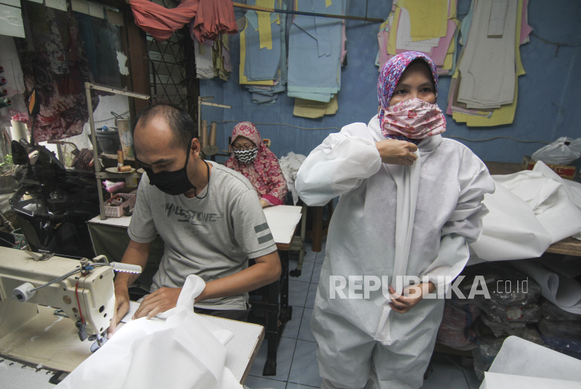 Pekerja membuat pakaian alat pelindung diri (APD) tenaga medis di konveksi rumahan, Depok, Jawa Barat, Senin (30/3/2020). Relawan Urunan Produksi memproduksi pakaian hazmat untuk dibagikan kepada tenaga medis di jabodetabek terkait mewabahnya virus corona atau COVID-19 di Indonesia