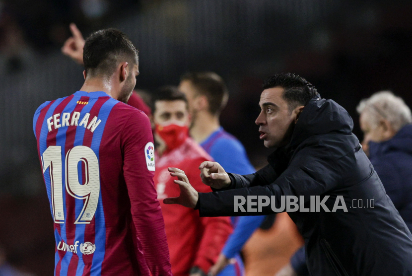  Pelatih kepala FC Barcelona Xavi Hernandez (kanan) berbicara dengan Ferran Torres (kiri) saat pertandingan sepak bola LaLiga Spanyol antara FC Barcelona dan Osasuna di Camp Nou di Barcelona, ??Spanyol,  Senin (14/3/2022) dini hari WIB.