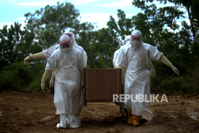Petugas memakamkan jenazah Pasien Dalam Pengawasan (PDP) COVID-19 di lahan pemakaman khusus.