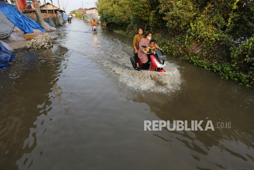 Sejumlah pengendara kendaraan bermotor melintasi banjir rob di Karangsong, Indramayu, Jawa Barat. Banjir rob yang disebabkan pasang air laut merendam jalan dan puluhan rumah warga yang berada di pesisir pantai. 