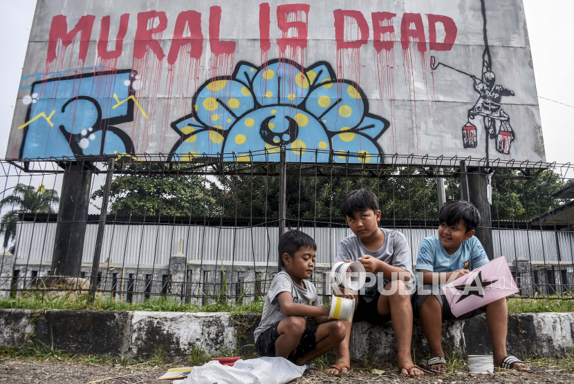 Sejumlah anak bermain di dekat mural yang bertuliskan Mural Is Dead di kawasan Monumen Perjuangan Rakyat Jawa Barat, Kota Bandung, Jumat (27/8). Mural tersebut merupakan bentuk ekspresi dari sejumlah seniman sekaligus media penyampaian kritik sosial kepada pemerintah di masa pandemi Covid-19.