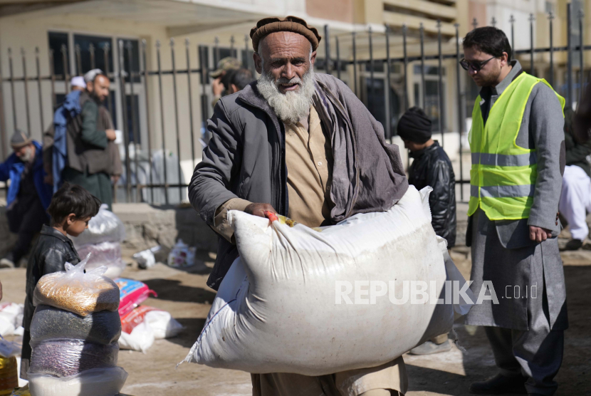  Seorang pria Afghanistan membawa sekarung tepung selama kampanye bantuan kemanusiaan untuk keluarga miskin, di Kabul, Afghanistan, Rabu, 16 Februari 2022. Afghanistan tercatat sebagai negara paling tidak bahagia di dunia selama dua tahun berturut-turut.