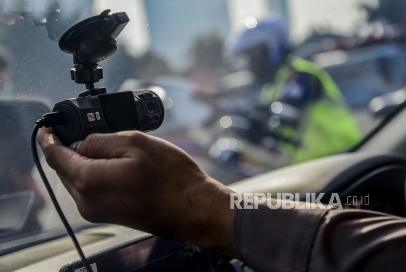 Anggota Kepolisian mengecek kamera yang dipasangkan di kaca mobil di Mapolda Metro Jaya, Jakarta, Sabtu (20/3). 