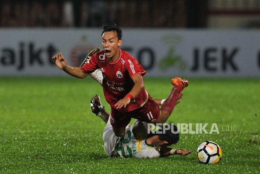 Gelandang Persija Jakarta Novri Setiawan dijegal pemain Persebaya Abu Rizal dalam laga lanjutan Liga 1 2018 di Stadion PTIK, Jakarta Selatan, Selasa (26/6).