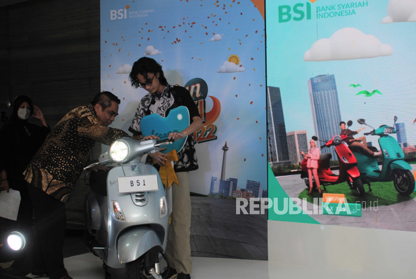 Direktur Sales & Distribution BSI Anton Sukarna (kiri) bersama pemenang melihat vespa saat penyerahan hadiah Program Hujan Rejeki BSI Mobile 2022 di Jakarta (15/5/2023). 