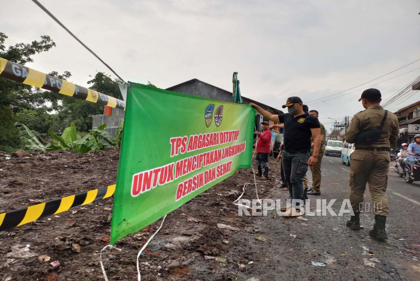 Personel Satuan Polisi Pamong Praja (Satpol PP) memasang garis dan spanduk penutupan tempat pembuangan sementara (TPS) Argasari di Jalan Bantar, Kecamatan Cihideung, Kota Tasikmalaya, Jawa Barat, Rabu (22/2/2023).