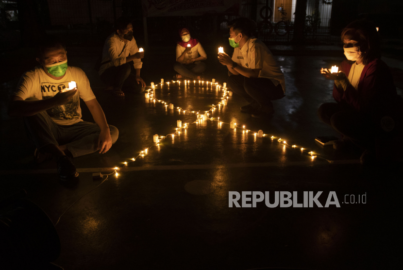 Relawan menyalakan lampu dalam malam renungan Hari AIDS Sedunia di Tanah Abang, Jakarta, Rabu (1/12/2021). Acara yang digelar secara gabungan oleh lembaga dan relawan pendamping orang dengan HIV/AIDS (ODHA) tersebut mengampanyekan kepada masyarakat untuk mewaspadai penularan virus HIV/AIDS dan lebih berempati pada penderitanya.