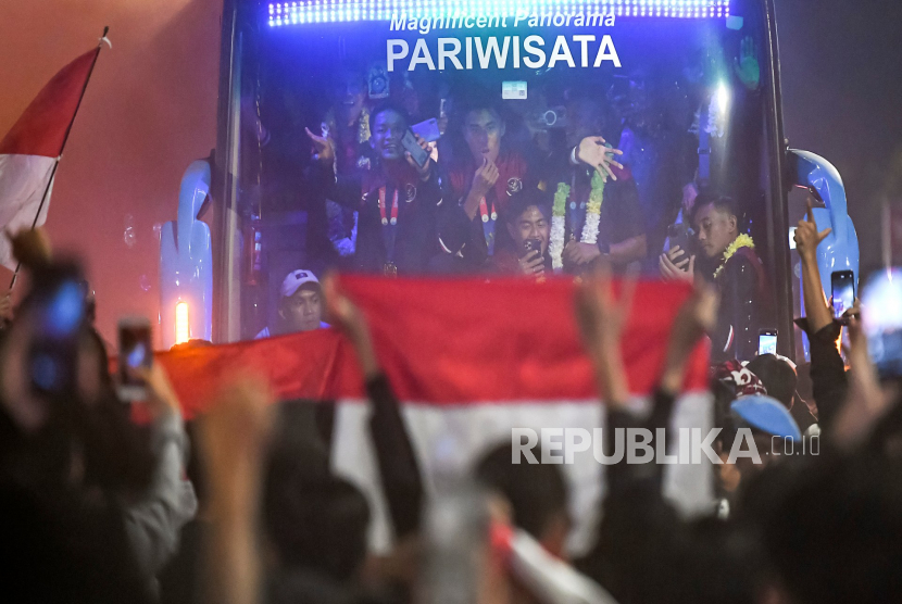 Sejumlah pesepak bola Timnas Indonesia U-22 melambaikan tangan ke arah suporter dari dalam bus di kawasan jalan Asia Afrika, Jakarta, Kamis (18/5/2023). Timnas Indonesia U-22 kembali ke Tanah Air usai meraih medali emas SEA Games Kamboja setelah mengalahkan Thailand dengan skor 5-2.  