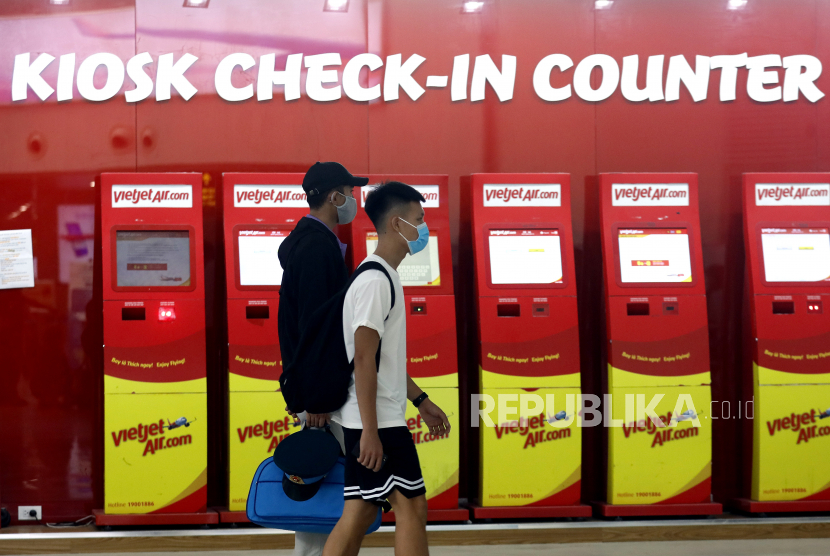 Orang-orang yang mengenakan masker berjalan melalui Bandara Internasional Noi Bai di Hanoi, Vietnam, 28 Juli 2020. Menurut laporan media, Vietnam telah mengevakuasi 80.000 orang, sebagian besar turis, dari Da Nang setelah wabah COVID-19 terdeteksi di daerah tersebut. 