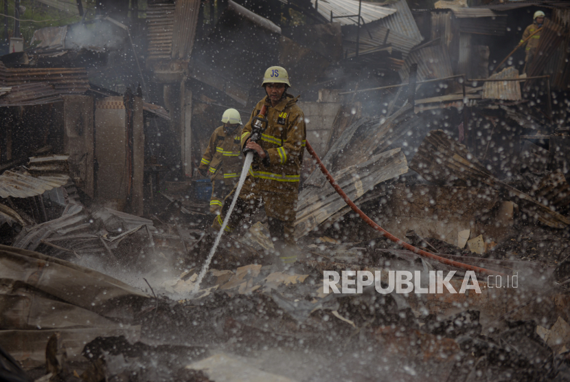 Petugas Penanggulangan Kebakaran dan Penyelamatan (Gulkarmat) melakukan proses pendinginan di lokasi kebakaran pemukiman di kawasan Simprug Golf II, Kebayoran Lama, Jakarta Selatan, Ahad (21/8/2022). Kebakaran tersebut terjadi sekitar pukul 10.48 WIB yang diduga akibat korsleting listrik di salah satu kontrakan di kawasan tersebut. 