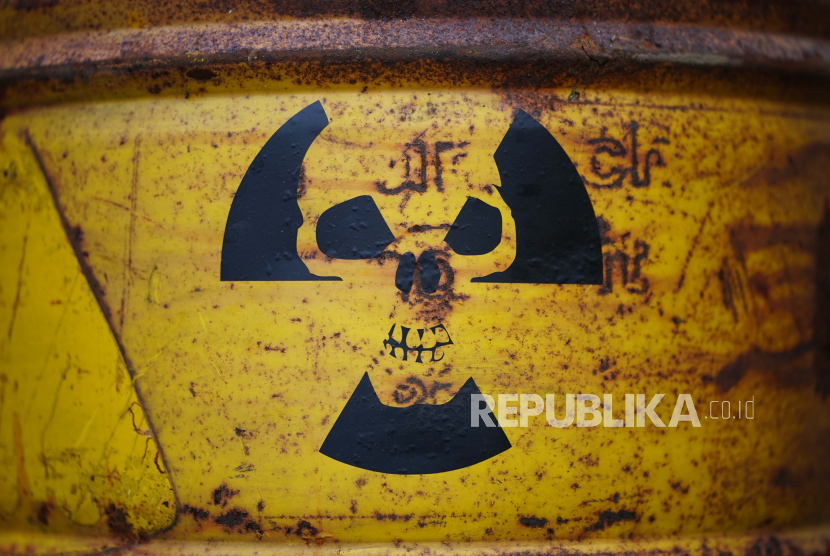 Simbol peringatan radiasi yang menggambarkan tengkorak terpampang pada tong kuning selama protes di depan parlemen Jerman 