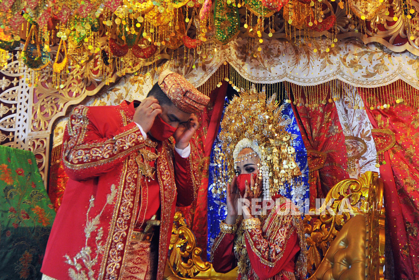 Pasangan pengantin menggunakan pakaian adat Minangkabau.