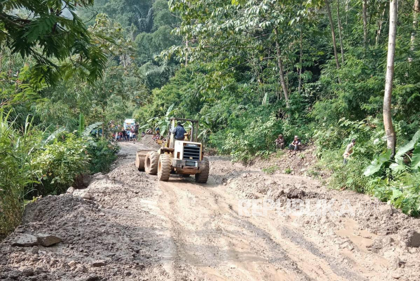 Petugas menggunakan alat berat untuk membuka akses jalan yang terdampak longsor di Ciwaru, Kecamatan Talegong, Kabupaten Garut, Jawa Barat, Kamis (27/4/2023). 