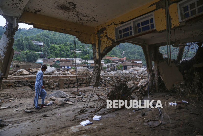 Seorang warga melihat rumah yang rusak akibat banjir bandang di lingkungan Pir Baba, wilayah distrik Buner, Pakistan, Ahad (17/8/2025).