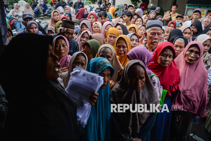 Warga antre menerima bantuan sosial. Gubernur Jawa Barat mewacanakan syarat vasektomi bagi penerima bansos.