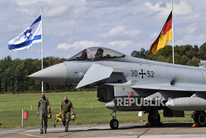  Bendera Israel dan bendera Jerman tertiup angin di belakang jet Eurofighter di pangkalan udara di Noervenich, Jerman, Kamis, 20 Agustus 2020.Pilot dari Israel dan Jerman akan terbang bersama selama dua minggu ke depan selama militer gabungan pertama Latihan Angkatan Udara antara kedua negara di Jerman.