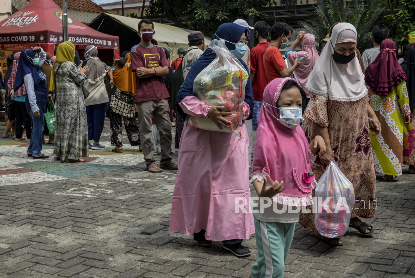 Warga membawa sembako murah. Pemkot Medan, Sumatra Utara, menggelar operasi pasar minyak goreng seharga Rp 13.500/liter.