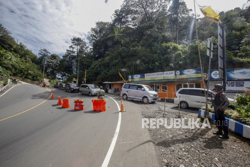 Petugas gabungan mengecek kendaraan yang melintas di titik pemeriksaan perbatasan Cianjur - Bogor, Jalan Raya Puncak, Kabupaten Cianjur, Jawa Barat, pekan ini. Petugas gabungan memperketat akses keluar masuk kendaraan yang melewati perbatasan dalam pemberlakuan Pembatasan Sosial Berskala Besar (PSBB) di Cianjur, Jawa Barat