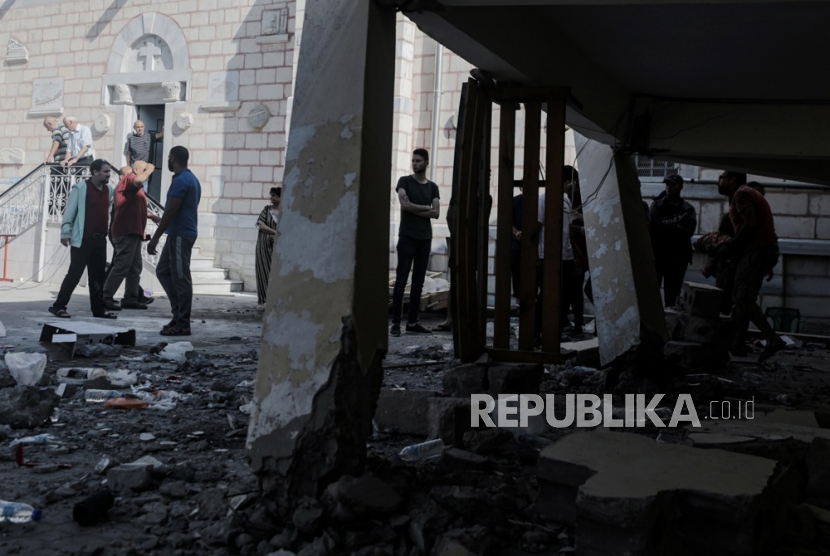 Orang-orang berdiri di dekat reruntuhan Gereja Ortodoks Yunani Saint Porphyrius setelah serangan udara semalam di Gaza, (20/10/ 2023).