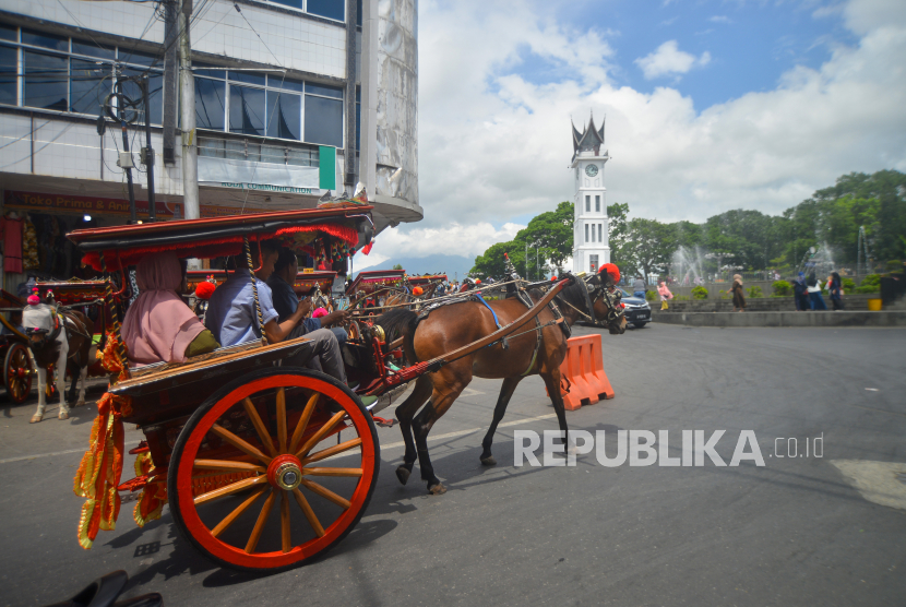Pengunjung menaiki bendi di areal Jam Gadang Bukittinggi, Sumatera Barat. Pemkot Bukittinggi kembali menggelar hari bebas kendaraan bermotor setelah pandemi.